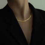 woman in black blazer wearing gold necklace