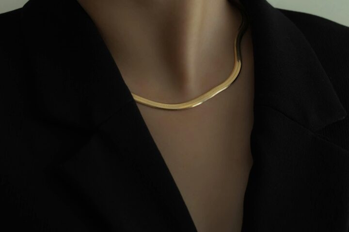 woman in black blazer wearing gold necklace